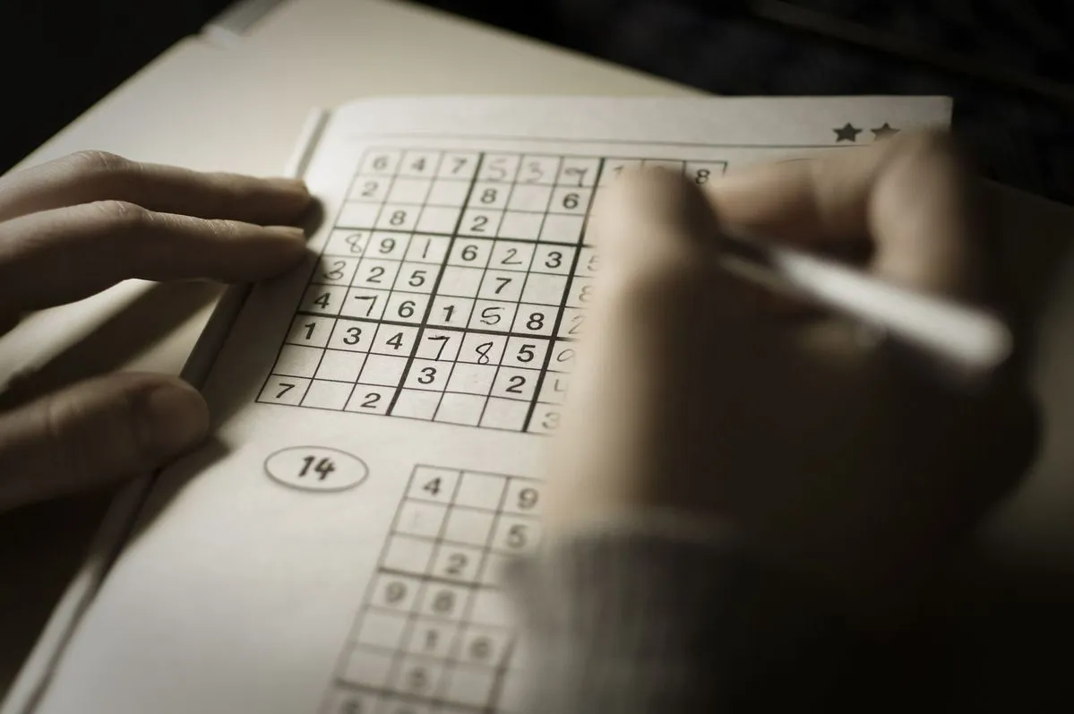 A printed logic puzzle being solved with a pencil